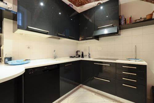 米蘭的住宿－Luxury Loft，厨房配有黑色橱柜和白色台面