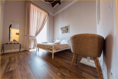 ein Schlafzimmer mit einem Bett, einem Stuhl und einem Fenster in der Unterkunft Villa Cua in Ercolano