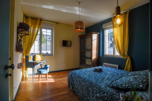 - une chambre avec un lit, un bureau et des fenêtres dans l'établissement L'EN VERT, à Bagnères-de-Bigorre