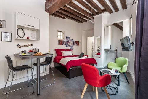 1 dormitorio con 1 cama, mesa y sillas en Le Saint-Aignan, Nuits-chartraines, Parking privé a quelques minutes, 3 étoiles en Chartres