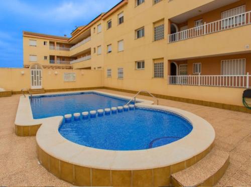 a swimming pool in front of a building at APARTAMENTO D&L CON ENCANTO- EN LOS ALCÀZARES-Totalmente equipado in Los Alcázares