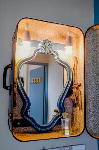 a suitcase with a mirror on a wall at L'EN VERT in Bagnères-de-Bigorre
