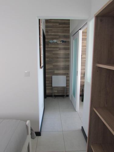 a hallway with a bed and a table in a room at Cantinho do Ilhéu in Ponta Delgada
