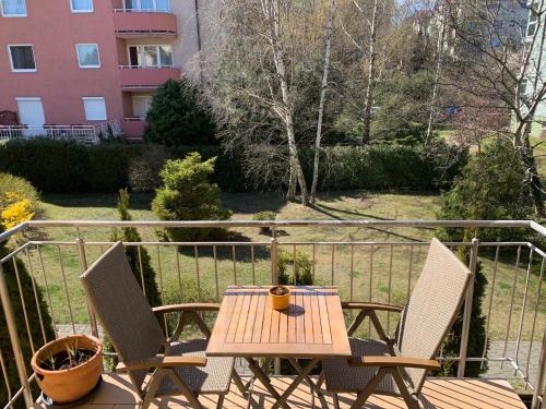 a wooden table and two chairs on a balcony at Sopocka Bryza in Sopot