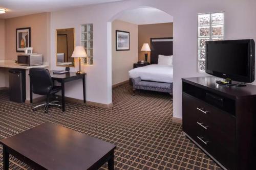 a hotel room with a bed and a desk with a television at Hotel Nova SFO in South San Francisco