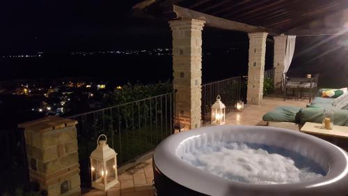 a bath tub on a deck at night with lights at Villa Isotta in Trevignano Romano