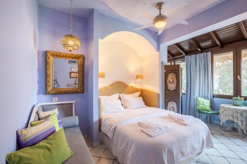 ein Schlafzimmer mit einem Bett in einem Zimmer mit lila Wänden in der Unterkunft Alterra Vita in Neos Marmaras