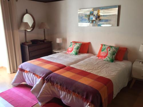 a bedroom with a large bed and a mirror at Quinta das Rosas in Capelas