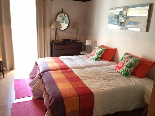 a bedroom with a bed with a colorful blanket at Quinta das Rosas in Capelas