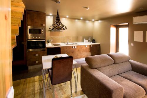 a living room with a couch and a table and a kitchen at RH Casas de Campo Design in Parada