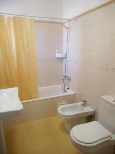 a bathroom with a toilet and a sink and a shower at Al Casa Paquito in Almograve