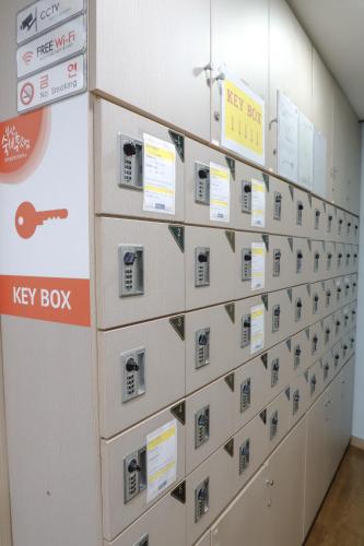 a row of lockers in a room with a key box at Busan Sukbak Dot Com Guesthouse in Busan