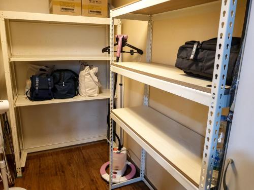 a walk in closet with shelves at Busan Sukbak Dot Com Guesthouse in Busan