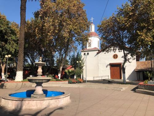 a fountain in front of a church with a clock tower at Casona Lo Aguirre , Hospedaje de Temporada Cálidas in Talagante