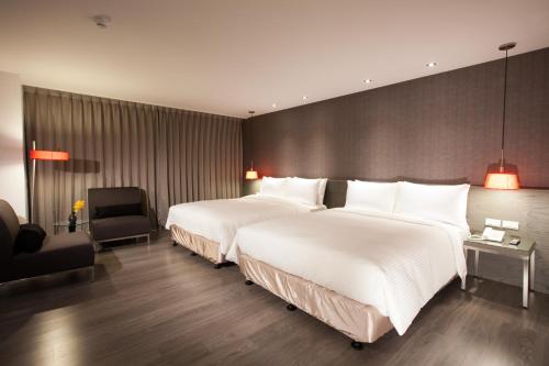 two beds in a hotel room with white sheets at CHECK inn SELECT Hualien LinSen in Hualien City