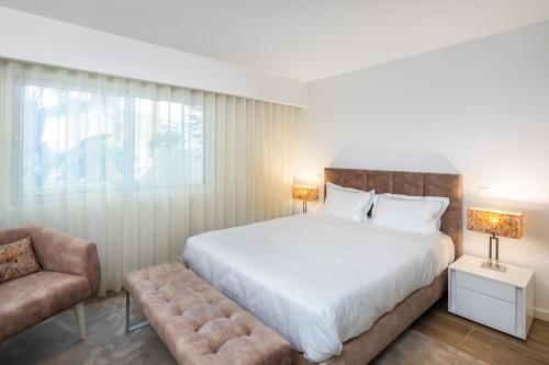 um quarto com uma cama grande e uma cadeira em Victory Village 3B em Quinta do Lago