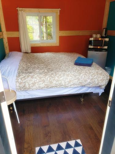 a bed in a small room with a window at New Buddha Bing Unique Experience Cottage and Cabins in Tobermory