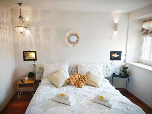 a bedroom with a white bed with pillows on it at In Casa in Verona