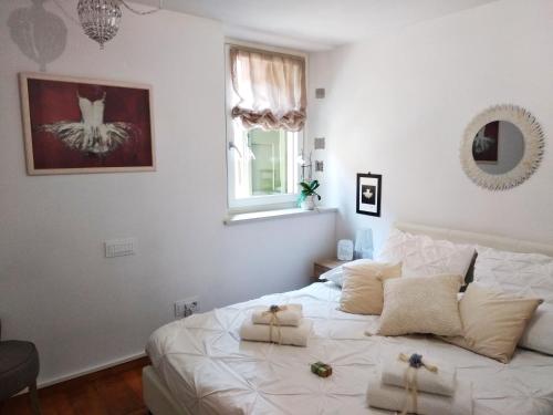 a bedroom with a white bed with towels on it at In Casa in Verona