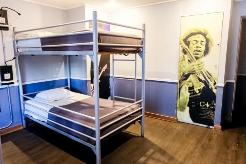 サンティアゴにあるGUANAKO Hostelの二段ベッド(壁にポスター付)が備わる客室です。