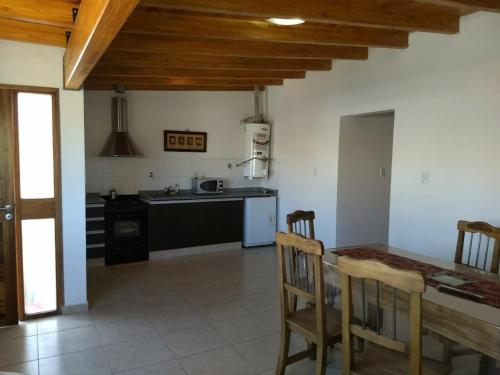 una cucina con tavolo, sedie e bancone di Departamentos modo turista a Tunuyán