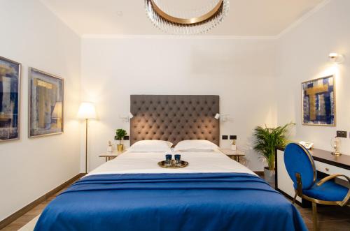 a bedroom with a large bed and a blue chair at Villa Brandestini in Pula