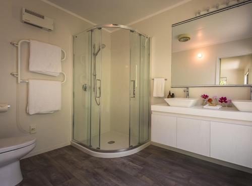 a bathroom with a glass shower and a sink at Golden Sands in Palm Beach