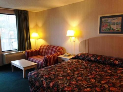 Habitación de hotel con cama y sofá en Royal Inn Columbia/Fort Jackson en Columbia