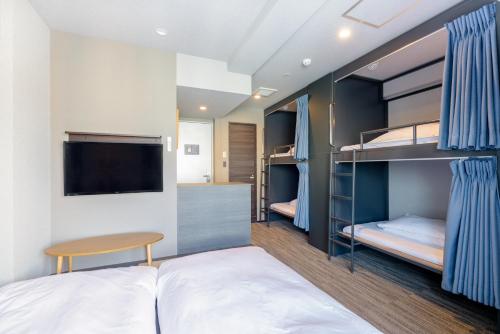 a bedroom with a bed and a television at Grids Tokyo Asakusa-bashi Hotel＆Hostel in Tokyo