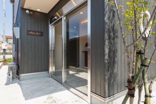 a glass entrance to a building with a window at Ambicia Sasebo in Sasebo