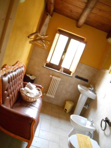 a bathroom with a couch and a sink and a window at Azienda Agrituristica Risveglio Naturale in Varese Ligure