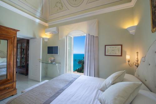 a bedroom with a bed with a view of the ocean at Villa Lauro Old Chapel in Amalfi