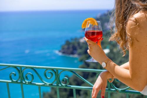 a woman holding a glass of wine on a balcony at Villa Lauro Old Chapel in Amalfi