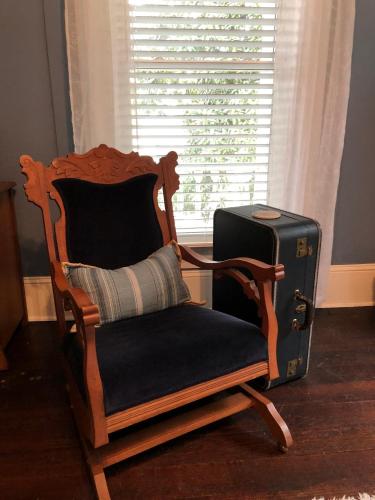 a chair and a suitcase sitting next to a window at Magnolia House & Gardens B&B in Clover