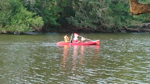 a group of people in a red boat on a river at The Backwaters Lodge in Wilpattu