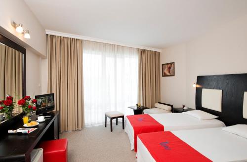 a hotel room with two beds and a desk at Calypso Hotel - All Incluisve in Sunny Beach