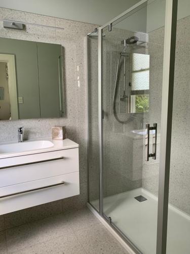 y baño con ducha acristalada y lavamanos. en Hawkes Bay Villa-Beechwood en Hastings
