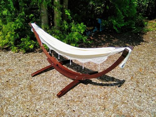 a hammock sitting on the ground in a yard at New Buddha Bing Unique Experience Cottage and Cabins in Tobermory