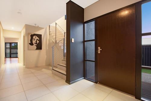 a hallway with a door and stairs in a house at Marina Views Townhouse in Darwin