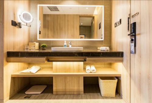 a bathroom with a sink and a mirror at Atour Jiaozhou Qingdao Hotel in Qingdao