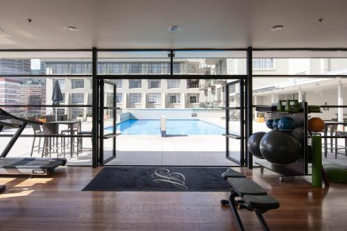 een fitnessruimte met uitzicht op een zwembad bij Private apartments in a Landmark Heritage Building in Auckland
