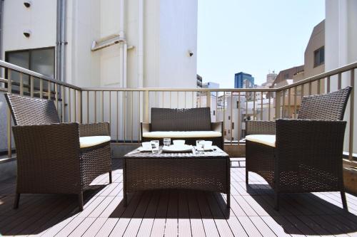 a patio with chairs and a table on a balcony at TERRACE HOUSE Shibuya Maruyamacho in Tokyo