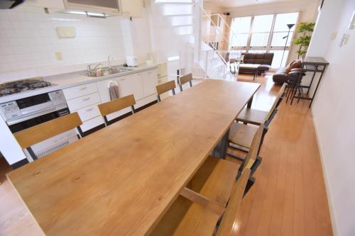 a large wooden table in a kitchen with chairs at TERRACE HOUSE Shibuya Maruyamacho in Tokyo