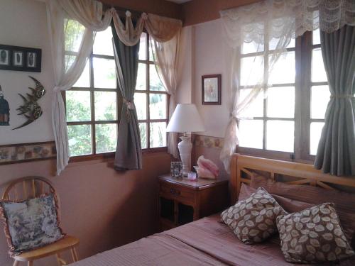 - une chambre avec un lit, des fenêtres et une chaise dans l'établissement San Andres Ultd Inn RNT # 30017, à San Andrés