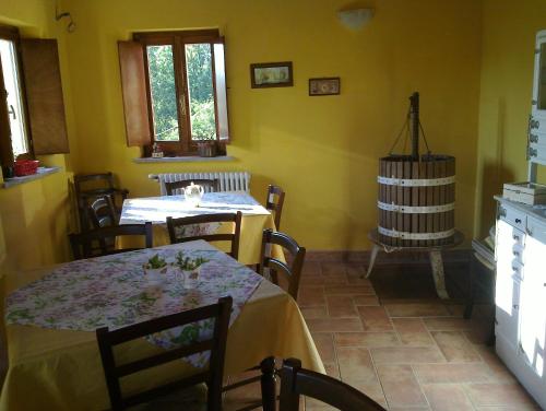 una sala da pranzo con tavolo, sedie e pareti gialle di Azienda Agrituristica Risveglio Naturale a Varese Ligure