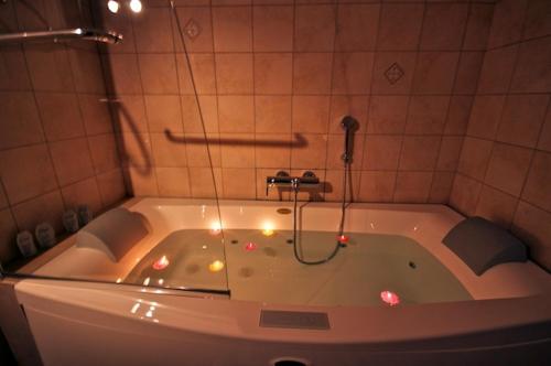 a bathroom with a tub with lights in it at Archontiko Papoutsi in Mouresi