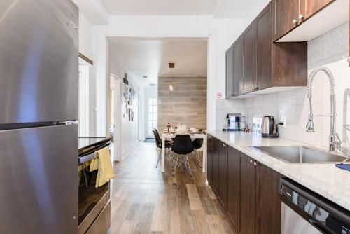 a kitchen with wooden cabinets and a stainless steel refrigerator at Apartments Near Montreal Olympic Park in Montréal