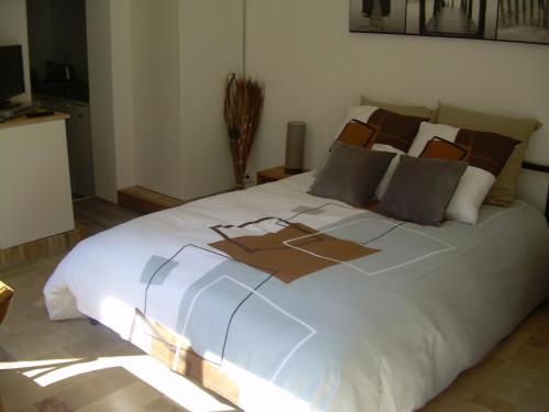 a bedroom with a large white bed with lights on it at L'Annexe in Anzin-Saint-Aubin