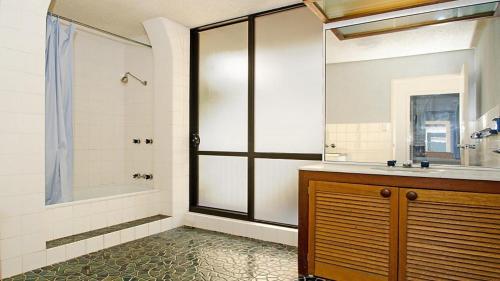 La salle de bains est pourvue d'une douche, d'un lavabo et d'une baignoire. dans l'établissement By The Sea Unit 4 13 Esplanade Kings Beach, à Caloundra