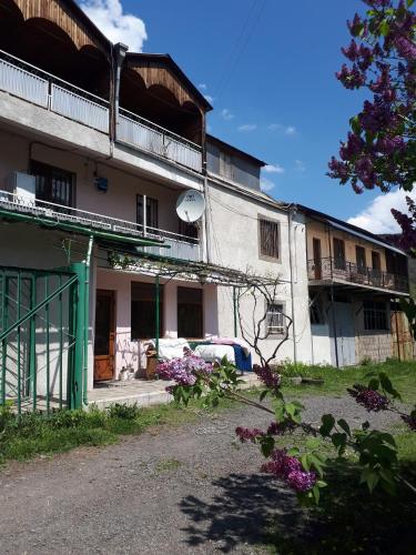 a white building with a green door and some flowers at IRIS B&B in DEBED CANYON in Alaverdi